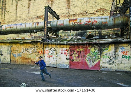 ST PETERSBURG, RUSSIA-APRIL 12, 2008: Boy playing soccer in poor area in city outskirts in Saint Petersburg, Russia