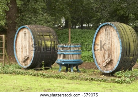 Two ancient wine barrels and a wooden wine press