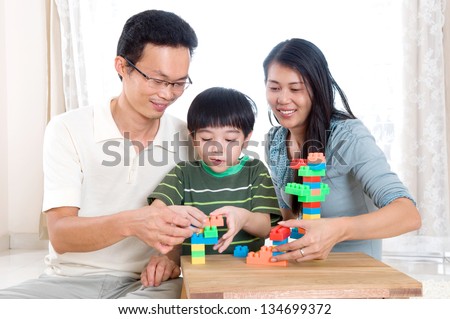 Asian family piling up building blocks