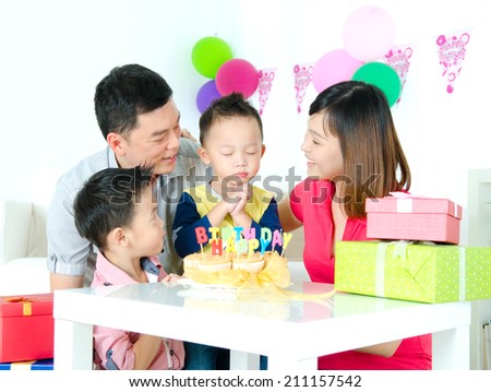 Asian boy make a wish on his birthday party