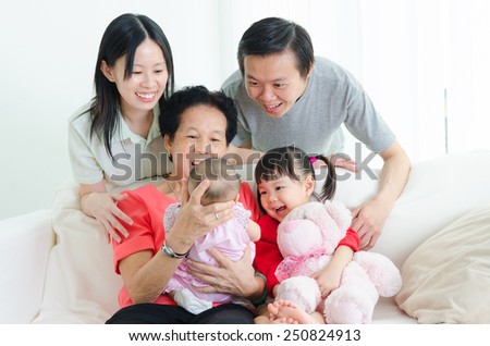 Asian three generations family looking at the new born baby.