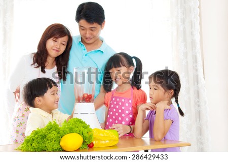 Asian family preparing fruits and vegetables juice