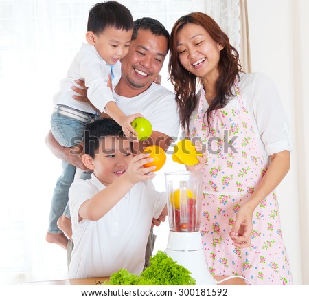Asian family preparing fruits and vegetables juice.