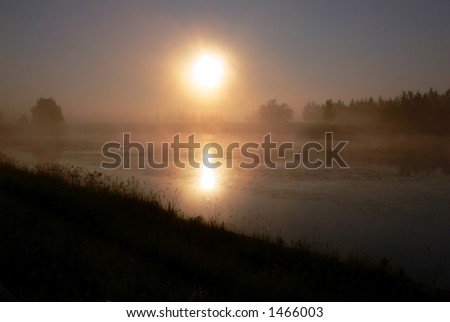 Sunrise over foggy lake