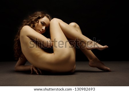 Beautiful naked body of young and sexy woman on dark background