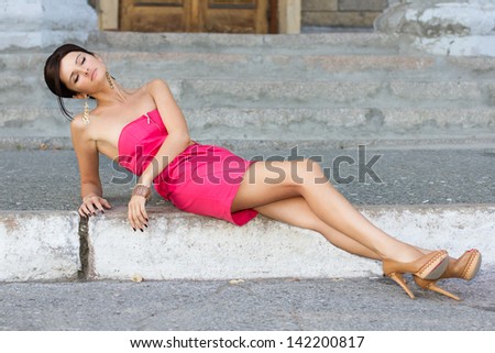 fashion urban portrait of young, slim, beautiful model  in pink dress