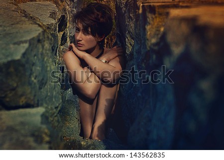 Sexy woman trapped in stones