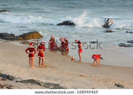 happy girls in Santa Clause suit having fun on the beach