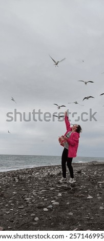 Similar – Foto Bild Mädchen füttert Möwe an der Küste