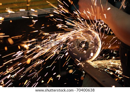 Worker cutting metal using angular grinding machine