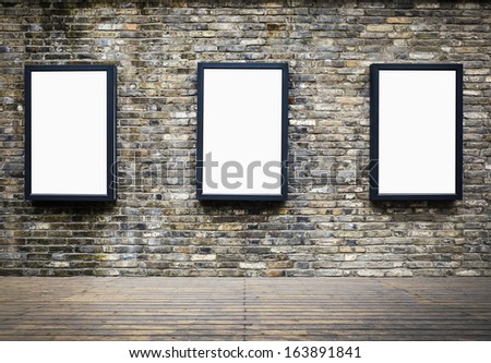 three blank billboards attached to a building exterior old brick wall