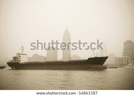 a big cargo ship sailing on huangpu river,old part of shanghai