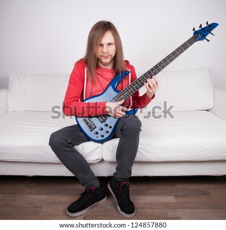 young guy playing guitar at home