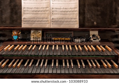 Closeup of the keys and sheet music on a pipe organ in a Christian church