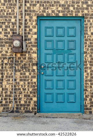 Solid turquoise door on brick wall