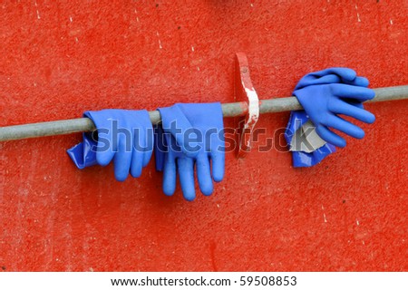 Blue gloves against red wall