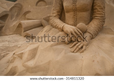 ALGARVE, PORTUGAL - August 6, 2015:  hands sand sculpture of unidentified artist at FIESA, International Sand Sculpture Festival in Algarve, Portugal.