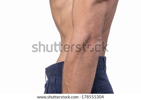 Profile of torso of shirtless man wearing blue pants sucking in his thin waist on white background 商業照片 © 