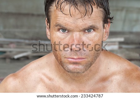 Closeup portrait of handsome rugged Caucasian male worker covered in dirt and sweat
