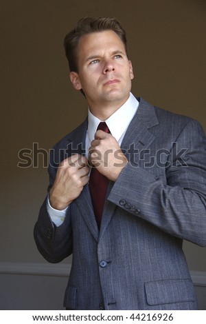 Business man adjusts his tie