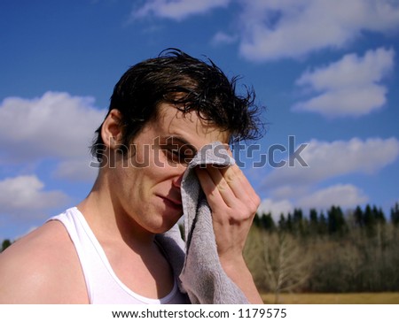 Exhausted runner taking a break and wiping his brow