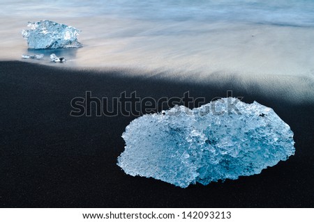 Crystal clear icebergs on the lava black beach in Iceland