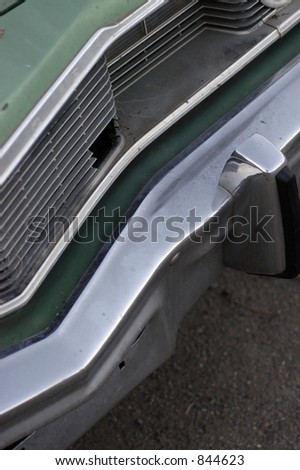 A seventies chrome bumper and damaged grille on an american automobile