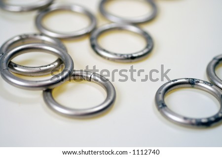 Slightly corroded metal rings scattered on a white surface