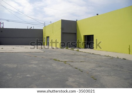 A vacant generic commercial building and parking lot in Southern California in lime green and grey