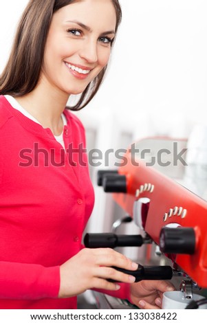 Female barista by coffee maker