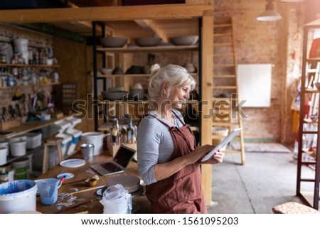 Similar – Image, Stock Photo Senior craftswoman with tablet computer in art studio