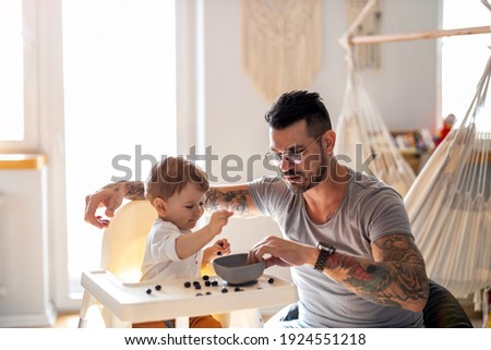 Similar – Image, Stock Photo Single dad feeding his baby who is sat in a high chair