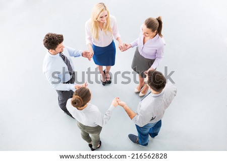 Business people holding hands to form a circle