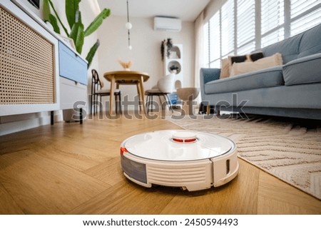 Image, Stock Photo A robot vacuum cleaner cleans the apartment diligently and independently and makes household chores easier