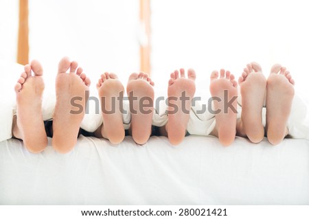 Feet of family in bed