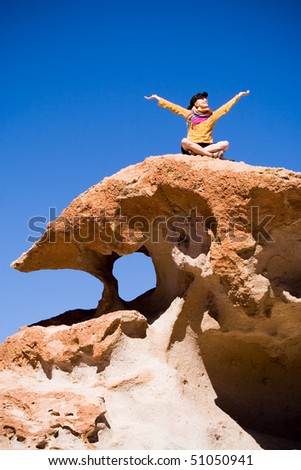 Woman sitting on volcanic rock, Bolivia