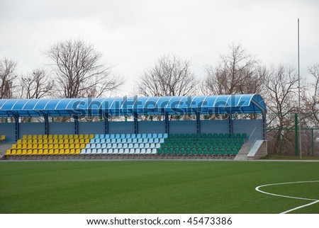 Covered stands with empty seats on small football stadium