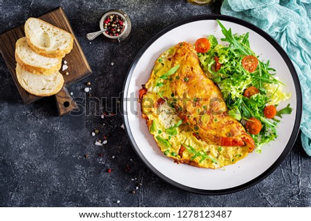 Breakfast. Omelette with tomatoes, avocado, blue cheese and green peas on white plate.  Frittata - italian omelet. Top view Stock fotó © 