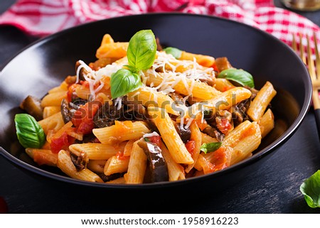 Pasta penne with eggplant. Pasta alla norma - traditional Italian food with eggplant, tomato, ricotta cheese and basil.