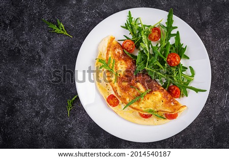 Breakfast. Omelette with tomatoes, cheese  and salad on white plate.  Frittata - italian omelet. Top view Stock fotó © 