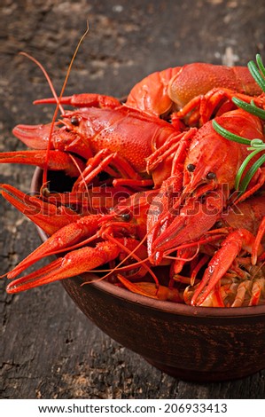 Bowl of fresh boiled crawfish on the old wooden background