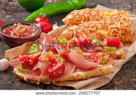 Sandwiches with ham and tomato salsa dip on a wooden background