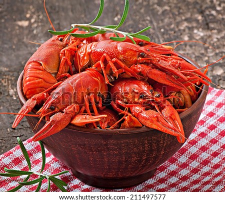 Bowl of fresh boiled crawfish on the old wooden background