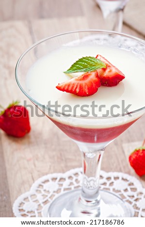 Strawberry panna cotta decorated with strawberries and mint leaf