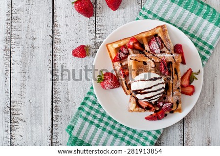 Belgium waffles with strawberries and ice cream  on white plate. Top view