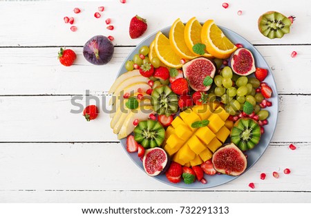 Platter fruits and berries. Mango, kiwi, fig, strawberry, grapes, pear and orange. Vegan cuisine. Dietary menu. Flat lay. Top view ストックフォト © 
