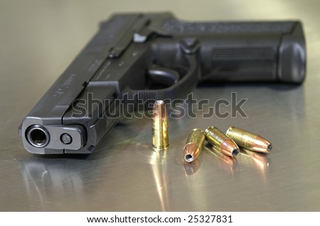 Black semi-automatic handgun with bullets, shallow depth of field