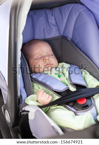 Cute little boy sleeping in car seat