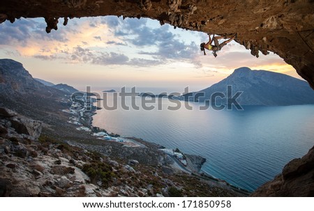 Female rock climber against picturesque view of Telendos Island at sunset. Kalymnos Island, Greece.