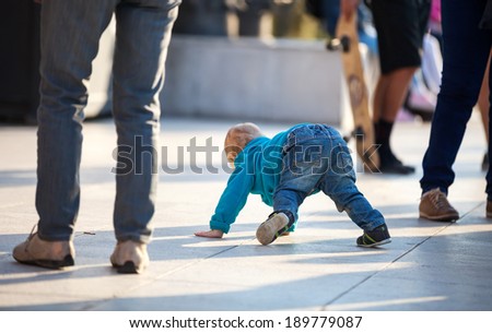 Little boy crawling among people